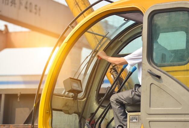 Man driving a crane to lift-up some equipments