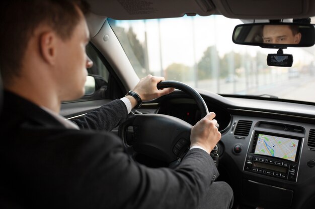 タクシーサービスのために彼のエレガントな車を運転している男