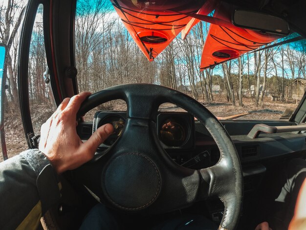 Man driving suv car by forest trail road