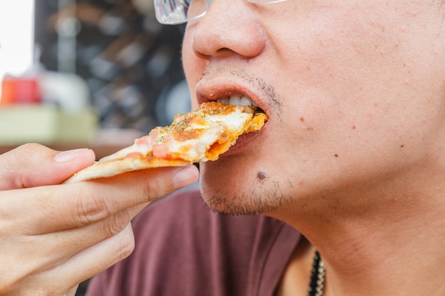 男はピザを食べる