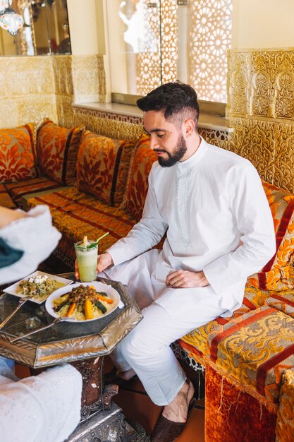Мужчина ест в ресторане араба