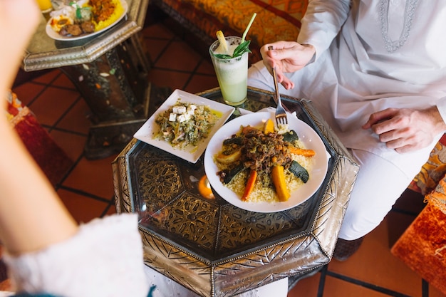 Free photo man eating in arab restaurant