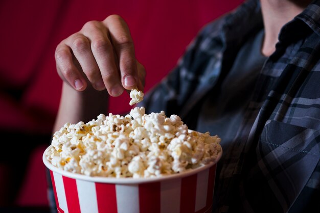 映画館でポップコーンを食べている男