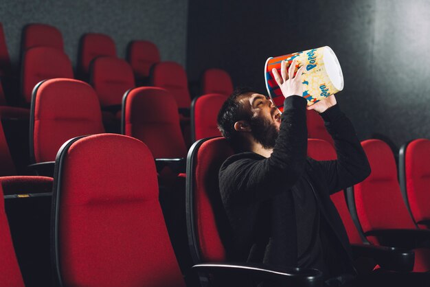 Man eating popcorn from bucket