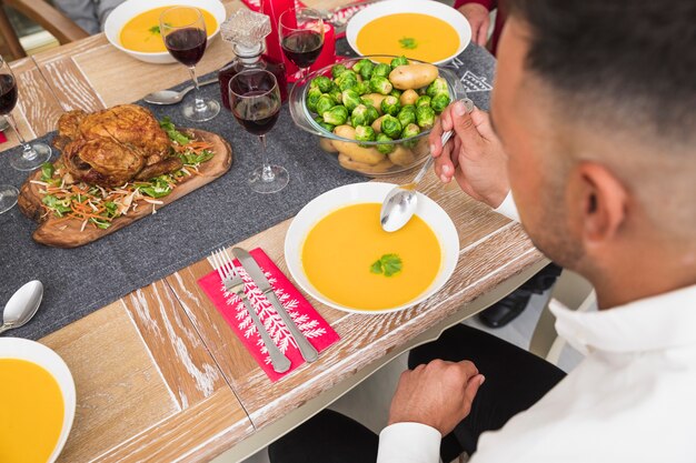 お祝いのテーブルでスープを食べる男