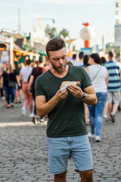 man eating street food. street hotdogs