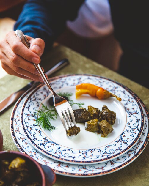 Man eats dolma with plain yougurt