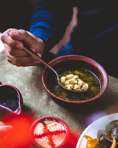 Man eats dushbara served with herbs