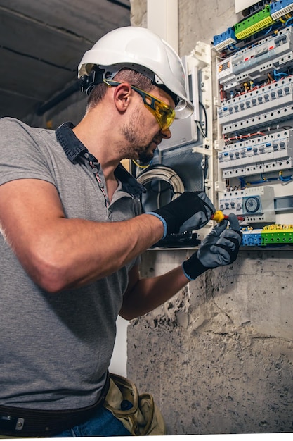 Free photo man an electrical technician working in a switchboard with fuses