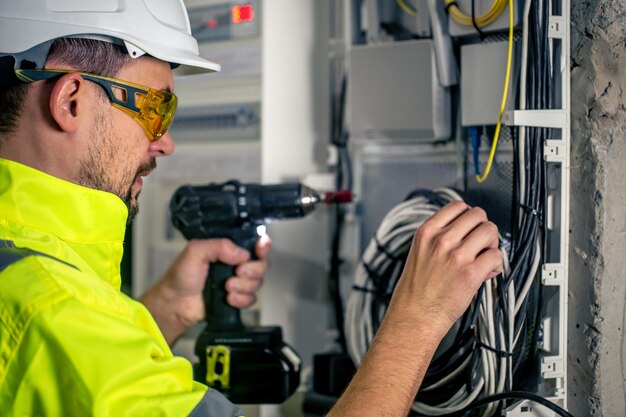 Man an electrical technician working in a switchboard with fuses