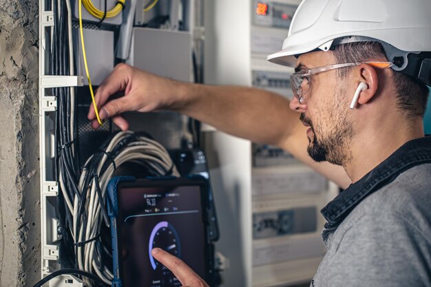 ヒューズ付きの配電盤で働く電気技術者の男性