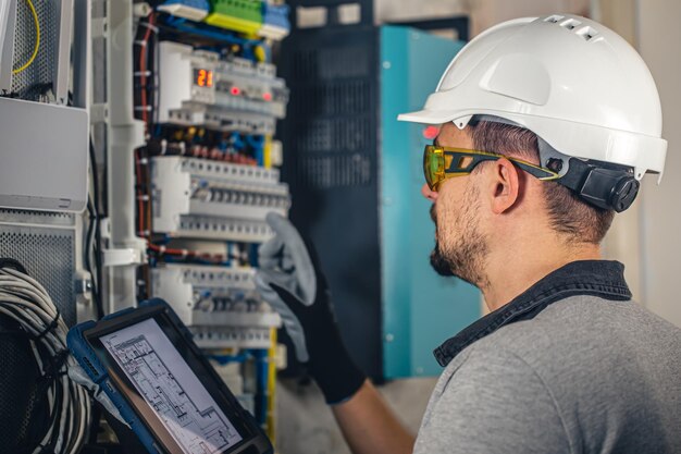 Man an electrical technician working in a switchboard with fuses