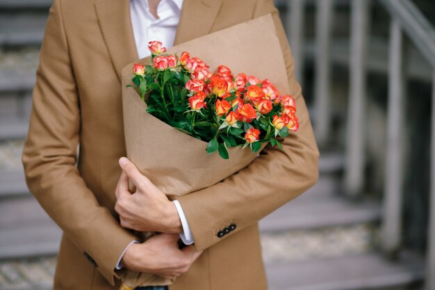 ペーパークラフトに折り畳まれた花の花束を抱きしめる男。