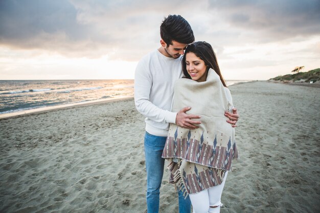 Man embracing his girlfriend on the beach