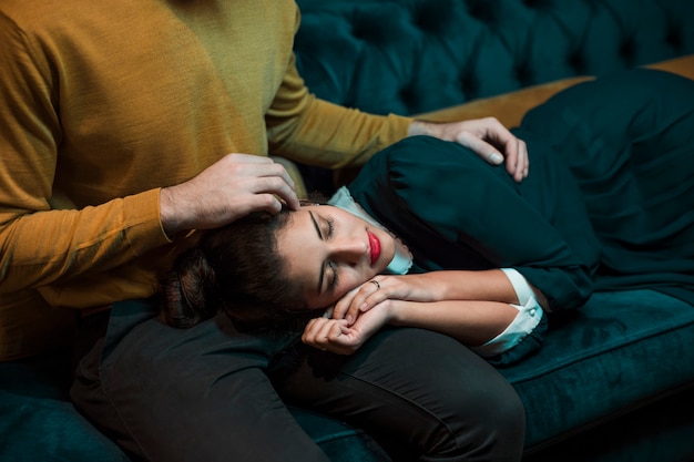 Free photo man embracing woman lying on legs