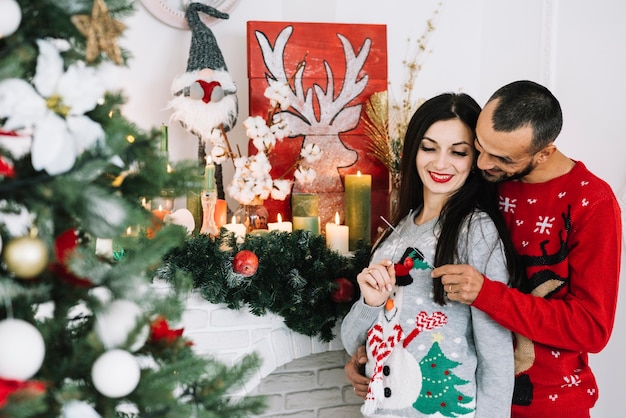 Man embracing woman near fireplace 