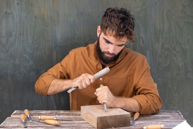 Free photo man engraving in wood outdoors