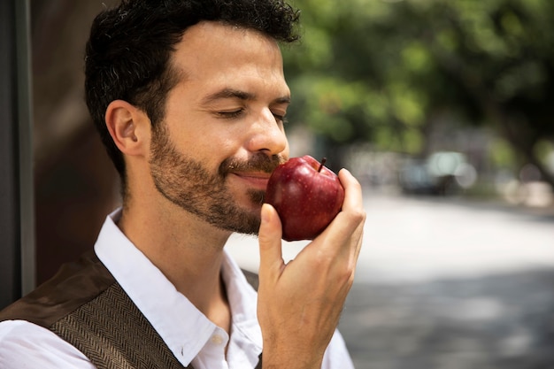 Man enjoying an apple outdoors