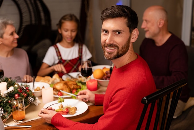 Foto gratuita uomo che si gode una cena di natale con la sua famiglia