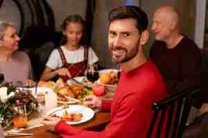 Free photo man enjoying a christmas dinner with his family