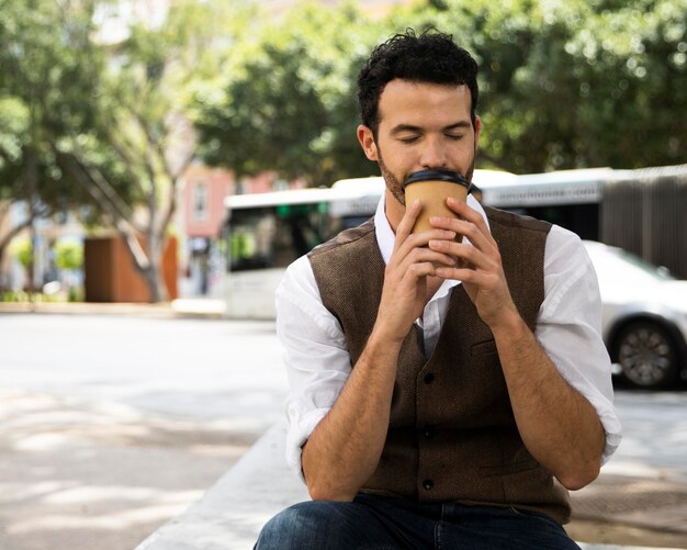 屋外で一杯のコーヒーを楽しんでいる男