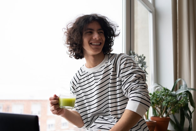 Foto gratuita uomo che si gode una tazza di tè matcha a casa