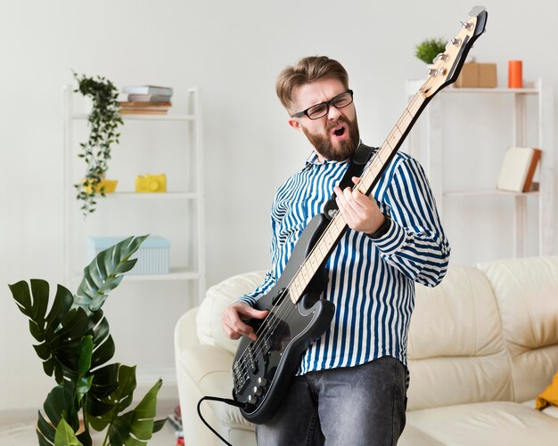 Человек наслаждается электрической гитарой дома