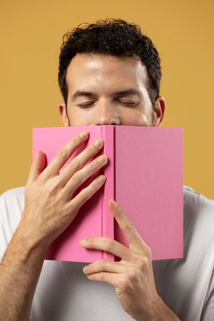 Free photo man enjoying the smell of a book