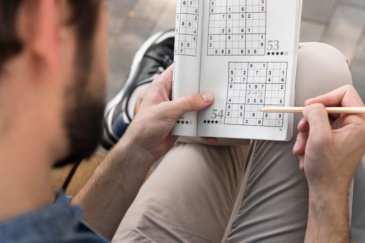 Free Photo man enjoying a sudoku game on paper