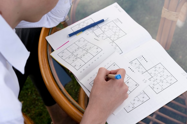 Free photo man enjoying a sudoku game on paper