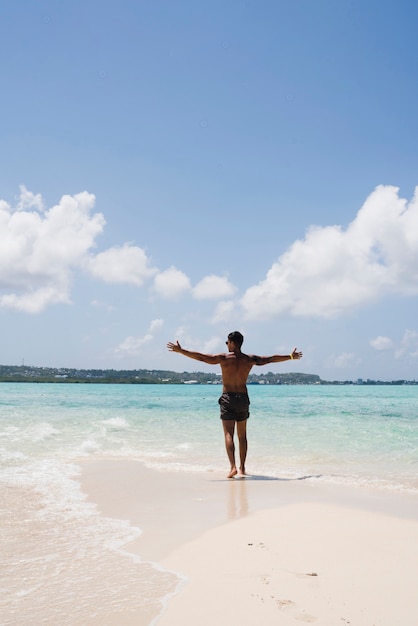 Бесплатное фото Человек наслаждается солнечным светом на пляже