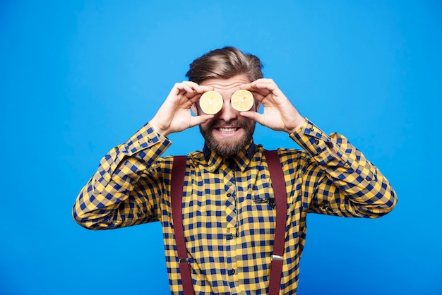 Foto gratuita uomo che si diverte con la frutta sugli occhi