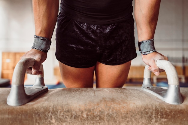 Man exercising on pommel horse close-up