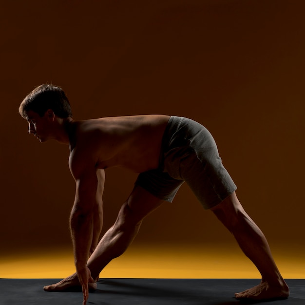 Человек тренируется на коврик для йоги