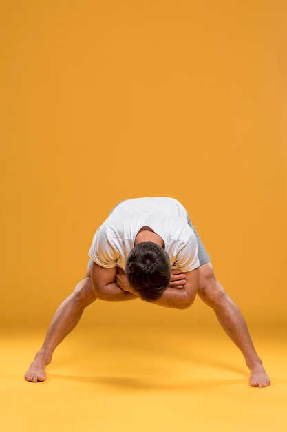 Foto gratuita uomo che si esercita nella posa di yoga