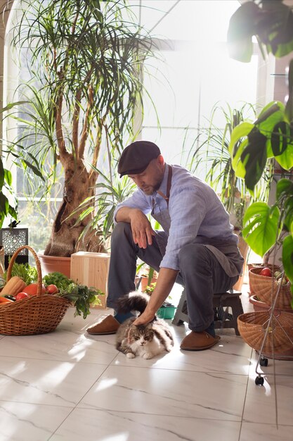 그의 실내 정원에서 야채를 재배하는 남자