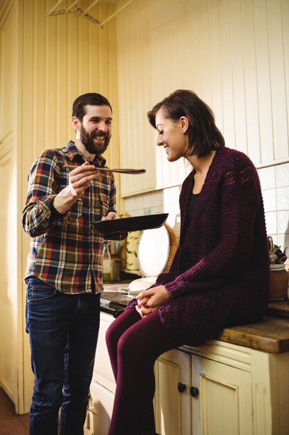 Man feeding food to woman