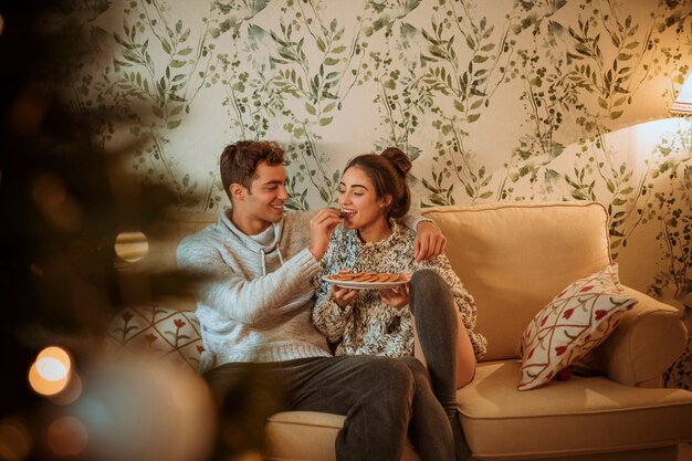 Man feeding woman with cookies 