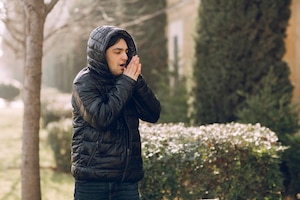 Man feeling cold in the black winter jacket in the park. high quality photo