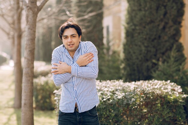 Man feeling cold in a shirt in the park. High quality photo