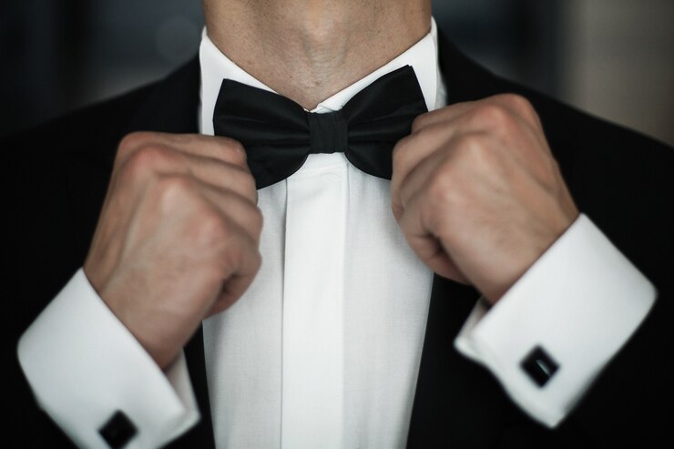 Free Photo man fies black bow tie on white shirt 