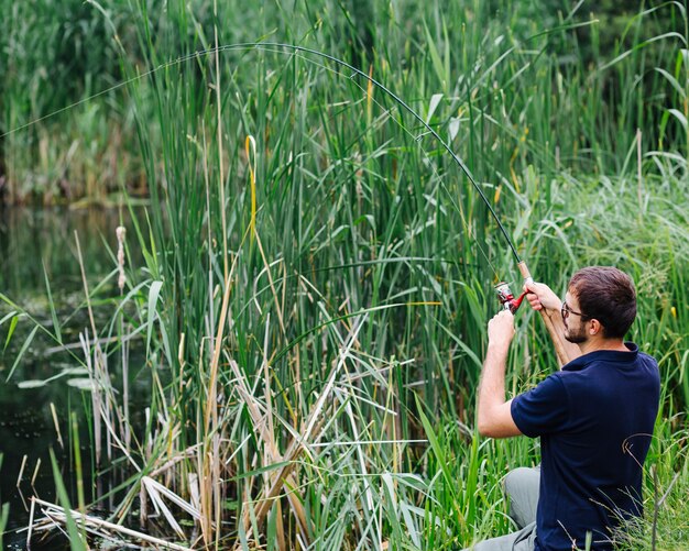 Man fishing in the grassy lake