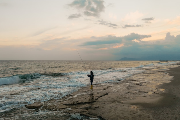 Man fishing on the sea shore