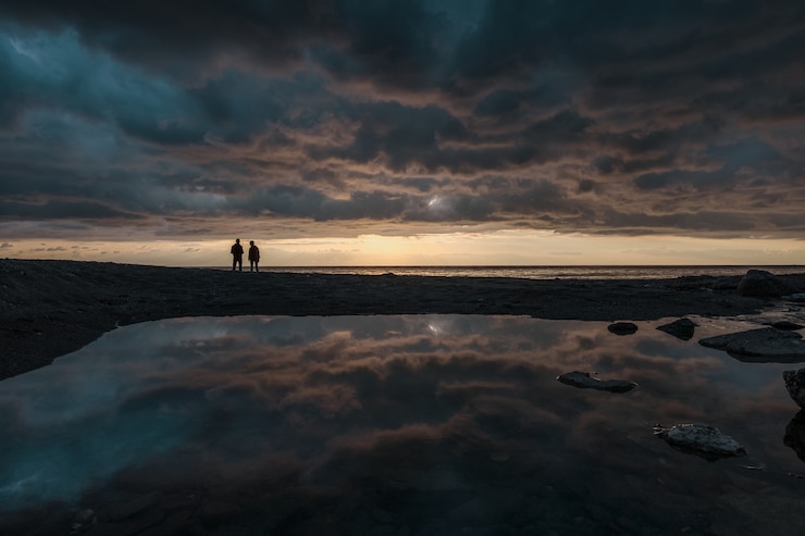 Free Photo man fishing at sunrise on the line of horizon