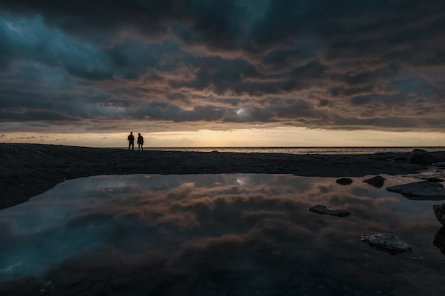 Man fishing at sunrise on the line of horizon