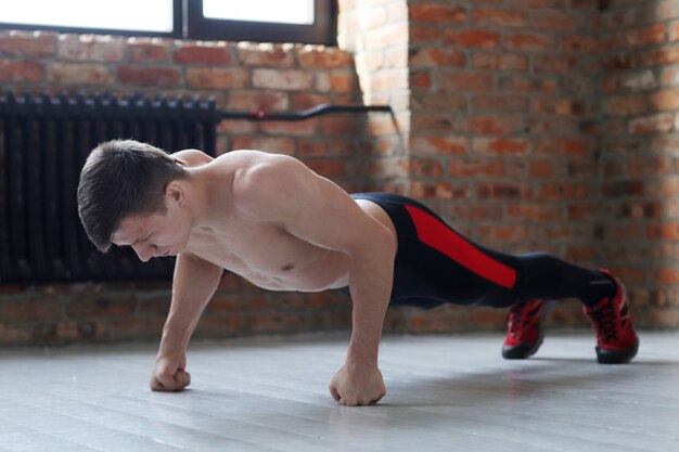 Man fitness workout. Shirtless man doing stretching at home