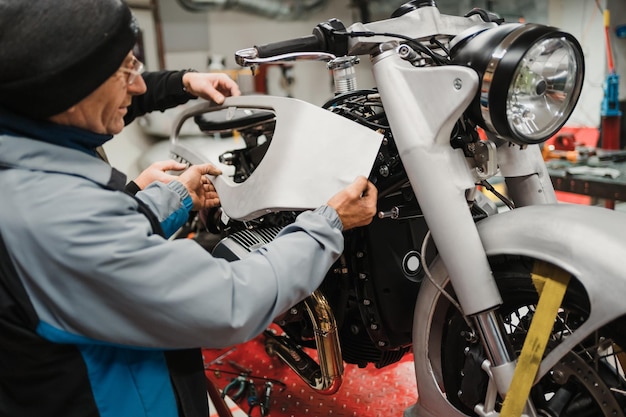 Man fixing a motorcycle in a modern workshop