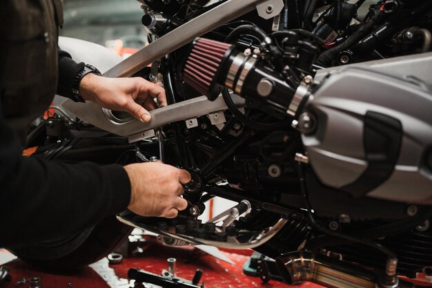 Man fixing a motorcycle in a modern workshop