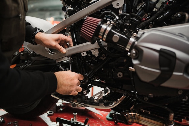 Man fixing a motorcycle in a modern workshop