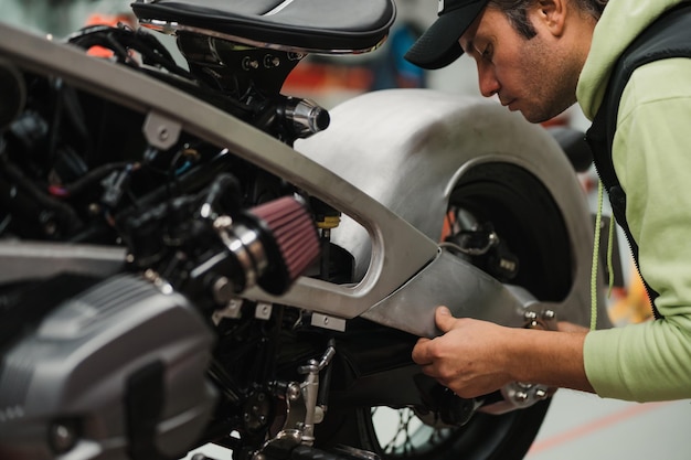 Man fixing a motorcycle in a modern workshop